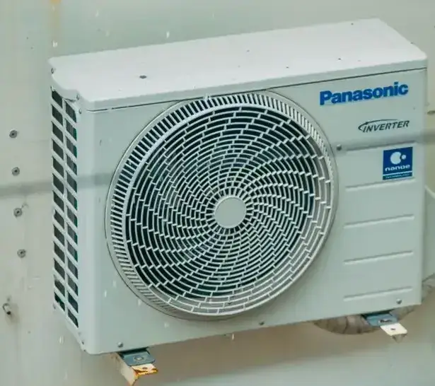 Air conditioner unit mounted outdoors on a building wall, showcasing modern HVAC technology.